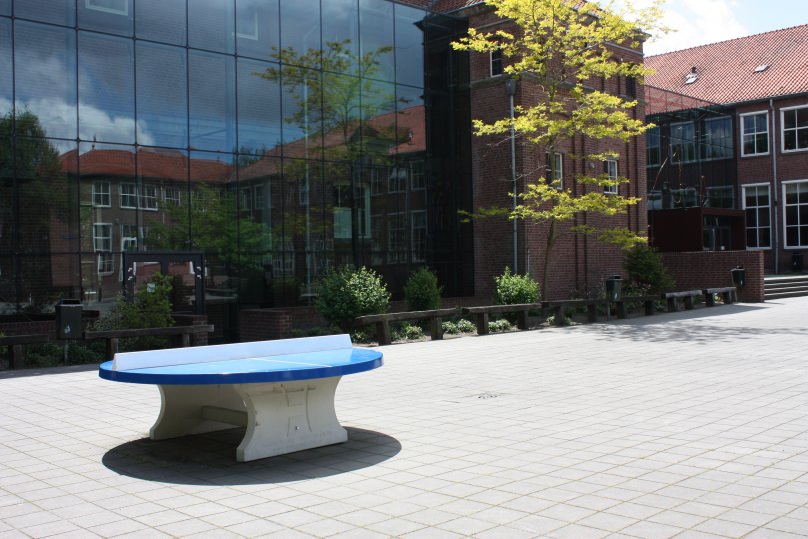 Ronde  betonnen pingpongtafel op schoolplein